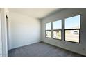 Bright bedroom with gray carpet and three large windows offering lots of natural light at 11441 E Utah Ave, Mesa, AZ 85212