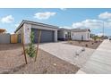 View of modern home with neutral colors, xeriscaping, and a paved driveway at 11441 E Utah Ave, Mesa, AZ 85212