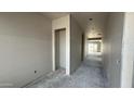 Hallway with visible wall studs and concrete flooring at 11441 E Utah Ave, Mesa, AZ 85212