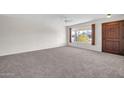 Spacious living room with carpeting and a view of the front yard at 12611 W Gable Hill Dr, Sun City West, AZ 85375