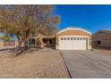 Tan house with a two-car garage, tree, and driveway at 13407 N Primrose St, El Mirage, AZ 85335