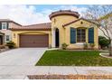 Charming home featuring a two-car garage, well-manicured lawn, and unique architectural details like a turret entrance at 15432 W Corrine Dr, Surprise, AZ 85379