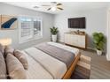 Main bedroom with large windows, a ceiling fan and wood flooring at 2014 N 94Th Gln, Phoenix, AZ 85037