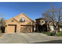 Two-story home with a three car garage and front yard landscaping at 20334 E Colt Dr, Queen Creek, AZ 85142