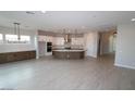 Spacious, modern kitchen with white cabinetry, stainless steel appliances, and a large center island at 21569 W Pierson St, Buckeye, AZ 85396