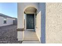 Front entry with arched alcove and dark green door at 25565 W Gwen St, Buckeye, AZ 85326