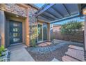 Private courtyard with stone pathway, modern door, and pergola at 27831 N Makena Pl, Peoria, AZ 85383