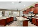 A spacious kitchen featuring granite countertops, cherry wood cabinets, and stainless steel appliances at 3559 E Bridgeport Pkwy, Gilbert, AZ 85295