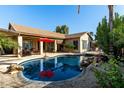 A beautiful backyard pool with rock features and a patio, perfect for outdoor relaxation and entertainment at 3559 E Bridgeport Pkwy, Gilbert, AZ 85295