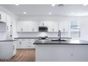 Modern kitchen with white cabinets, dark countertops, and stainless steel appliances at 4120 E Ghost Flower Ln, San Tan Valley, AZ 85140