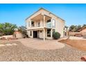 Expansive backyard showcasing a two-story home with a brick patio, fire pit, and desert landscaping at 5010 E Mesquite Wood Ct, Phoenix, AZ 85044