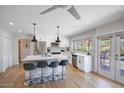 Modern kitchen features white cabinets, an island with seating, and opens to the backyard at 5201 E Winchcomb Dr, Scottsdale, AZ 85254