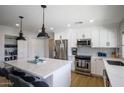 Bright kitchen boasts white cabinets, quartz countertops, and a large island at 5201 E Winchcomb Dr, Scottsdale, AZ 85254