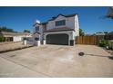 Two-story house with a gray-trimmed white exterior, a two-car garage, and a basketball hoop at 6073 W Caribe Ln, Glendale, AZ 85306