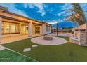 Outdoor oasis with fire pit, turf, and basketball court at 7556 W Crystal Rd, Glendale, AZ 85308