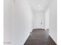 Clean hallway features white walls, recessed lighting, and wood-look tile floors at 8432 W Solano Dr, Glendale, AZ 85305