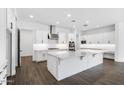 Spacious kitchen with white cabinets, quartz countertops, stainless steel appliances, and large island at 8432 W Solano Dr, Glendale, AZ 85305