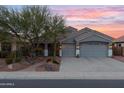 Gray two-story house with a three-car garage and nicely landscaped front yard at 12522 W Llano Dr, Litchfield Park, AZ 85340