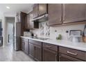 Modern kitchen with stainless steel appliances and dark brown cabinets at 17669 W Daley Ln, Surprise, AZ 85387