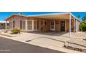 Single-wide manufactured home with carport and desert landscaping at 2400 E Baseline Ave # 84, Apache Junction, AZ 85119