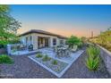 Relaxing backyard patio with dining and lounge seating, surrounded by desert landscaping at 30343 N 130Th Dr, Peoria, AZ 85383