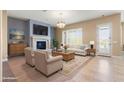 Bright living room featuring a cozy fireplace, tile flooring, and comfortable seating arrangement at 31689 N 128Th Dr, Peoria, AZ 85383