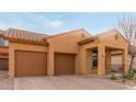 Tan house with a two-car garage and desert landscaping at 3923 E Kesler Ln, Gilbert, AZ 85295