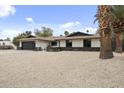 Attractive single-story home featuring desert landscaping, modern garage door, and dark accents at 4059 E Cholla St, Phoenix, AZ 85028