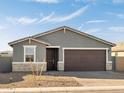 Inviting exterior features neutral stucco, stone accents, well-kept gravel landscaping, and a convenient two-car garage at 4267 W Jeanette Ln, San Tan Valley, AZ 85144