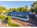 Beautiful home with a well-kept lawn, a long driveway, mature trees, and a white picket fence at 5249 E Thunderbird Rd, Scottsdale, AZ 85254