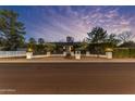 Charming single-story home featuring manicured landscaping, stone pillars, and subtle exterior lighting at dusk at 5249 E Thunderbird Rd, Scottsdale, AZ 85254