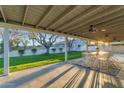 Inviting covered patio with ceiling fans, outdoor dining area, and a view of the lush backyard at 5249 E Thunderbird Rd, Scottsdale, AZ 85254