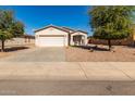 Front view of a single-story house with a driveway and landscaping at 7420 W Glass Ln, Laveen, AZ 85339