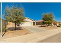 View of a single-story home with mature landscaping and a long driveway at 7420 W Glass Ln, Laveen, AZ 85339