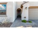 Front entrance with dark door, arched entryway, and brick walkway at 9625 E Spiral Ave, Mesa, AZ 85212