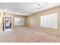 Spacious living room with neutral carpeting and plantation shutters at 11625 W Jackson St, Avondale, AZ 85323