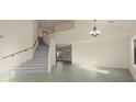 Bright, open-concept living space with staircase, tile floors, and chandelier lighting at 15727 W Rimrock St, Surprise, AZ 85374