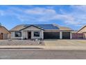 House exterior featuring a three-car garage and solar panels at 17600 N 64Th Dr, Glendale, AZ 85308