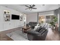 This living room features stylish decor, a ceiling fan, and a sliding glass door to the backyard at 3711 E Sandy Way, Gilbert, AZ 85297