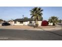 Charming single story home with a spacious front yard and mature palm trees at 4402 W Verde Ln, Phoenix, AZ 85031