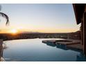 Infinity pool overlooking city and mountain views at sunset at 5113 W Arrowhead Lakes Dr, Glendale, AZ 85308