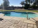 Inviting kidney-shaped pool with brick patio at 6124 N 130Th Ave, Litchfield Park, AZ 85340