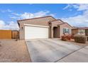 Tan colored house with a white garage door and landscaping at 670 E Wiley Way, Casa Grande, AZ 85122