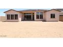 View of the rear exterior of home showing large windows and sliding doors, along with an expansive backyard at 6818 N 190Th Ave, Waddell, AZ 85355