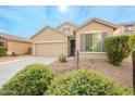 Tan house with gray shutters, two-car garage, and landscaped front yard at 7225 W Jones Ave, Phoenix, AZ 85043