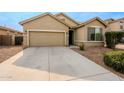 Tan house with gray shutters, two-car garage, and landscaped front yard at 7225 W Jones Ave, Phoenix, AZ 85043