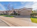 Attractive single story home with light brown exterior and neatly landscaped yard at 8687 E Tuckey Ln, Scottsdale, AZ 85250