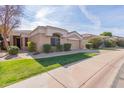 Tan colored single story home with well manicured landscaping and a large driveway at 8687 E Tuckey Ln, Scottsdale, AZ 85250