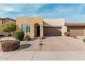 Tan house with a two-car garage and landscaped front yard at 880 E Verde Blvd, Queen Creek, AZ 85140