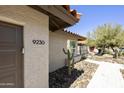 Close up of home with house number, tan stucco, terracotta tile roof and desert landscaping at 9230 N 104Th Pl, Scottsdale, AZ 85258